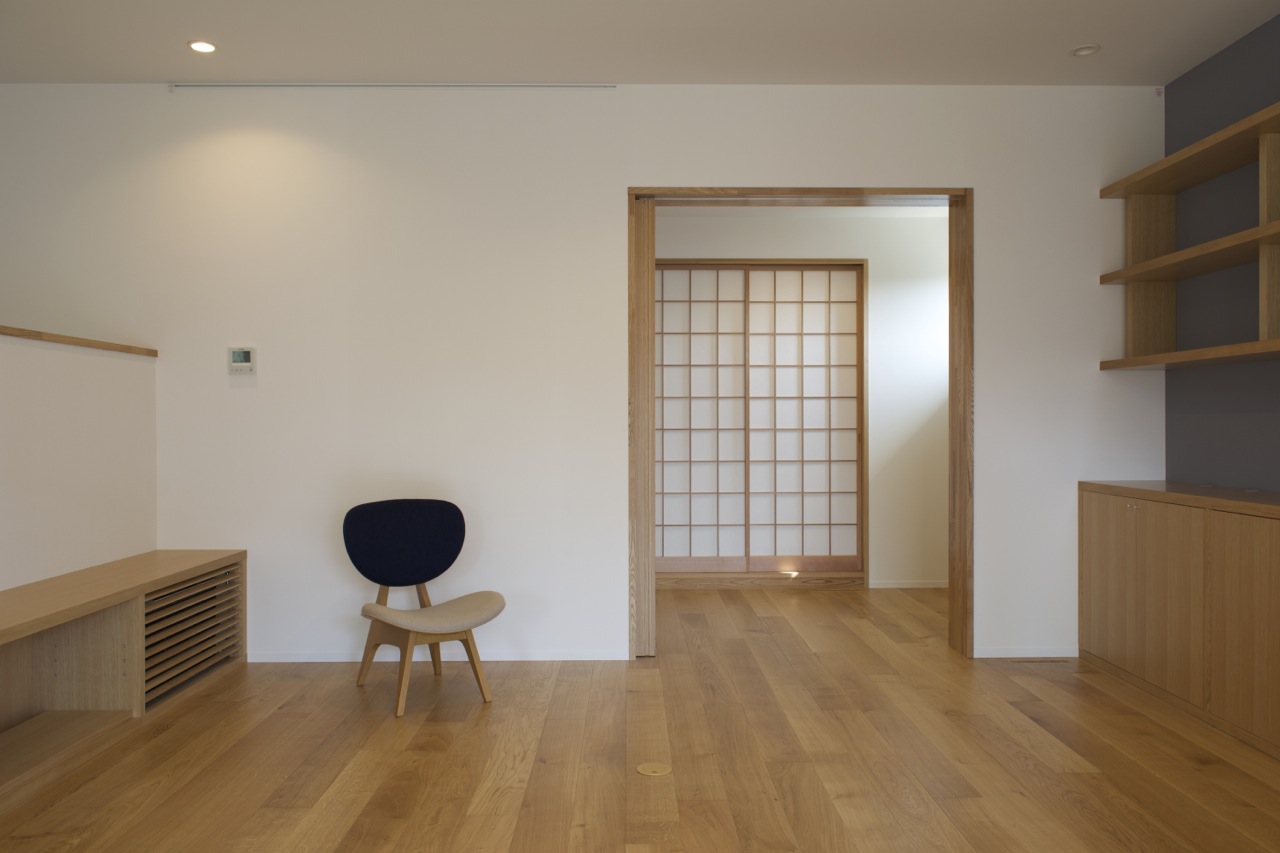 Living area with TV shoves on the left, bookshelves on the right and piano room and the Japanese room sliding doors closed.   Living area with TV shoves on the left, bookshelves on the right and piano room and the Japanese room sliding doors closed.